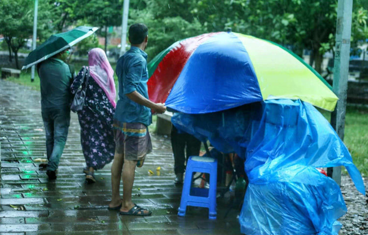 ফুটপাতে ভিজে যাচ্ছে দোকানের পসরা, পথচারীদের মুখে কষ্টের রেখা, তবুও যেন অভ্যস্ততায় আটকে থাকা এই শহরের মানুষ থেমে নেই।