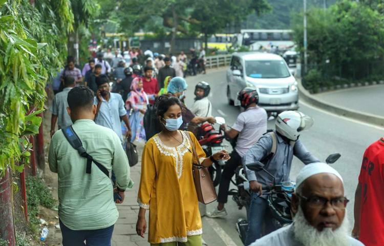 সকাল ৮টার দিকেই দেখা গেছে, বাসের জন্য অপেক্ষমাণ কর্মজীবী নারী-পুরুষদের দীর্ঘ সারি। কেউ ছাতা মাথায়, কেউ রোদে পুড়ে অপেক্ষা করছেন বাসের জন্য।