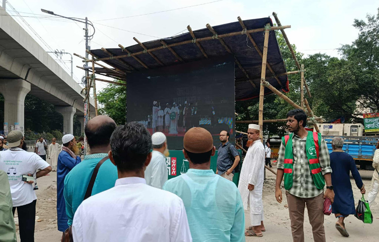 শাহবাগে জামায়াতের সমাবেশ দেখার জন্য স্ক্রিনে চোখ রাখছেন পথচারীরা। ছবি: সালাহ উদ্দিন জসিম