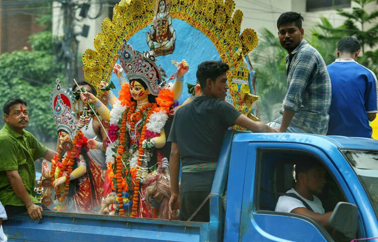 বিকেল থেকেই ট্রাকে করে একে একে প্রতিমা নিয়ে আসতে থাকেন সনাতন ধর্মাবলম্বীরা।