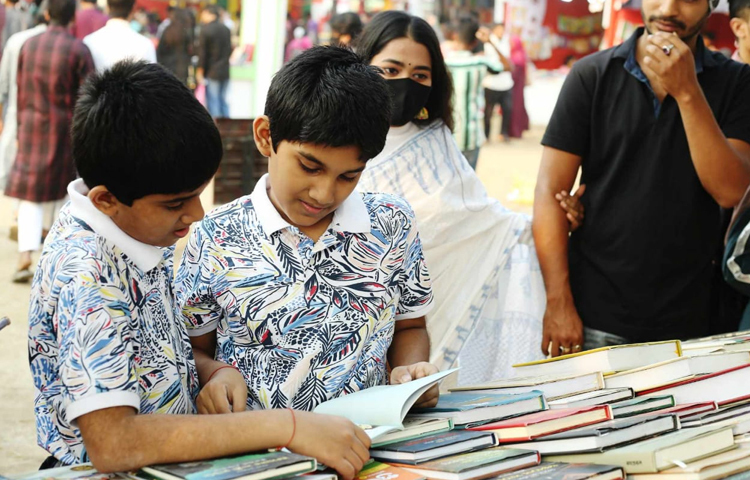 পছন্দে বই দেখতে ব্যস্ত দুই শিশু। ছবি: মাহবুব আলম