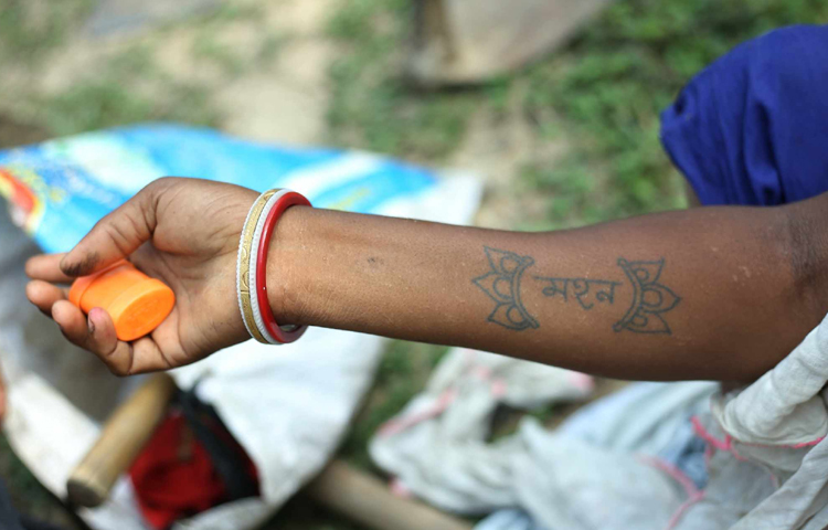 নিজের হাতে স্বামীর নাম লিখিয়েছেন মাধবী নামের এক চা শ্রমিক। ছবি: মাহবুব আলম