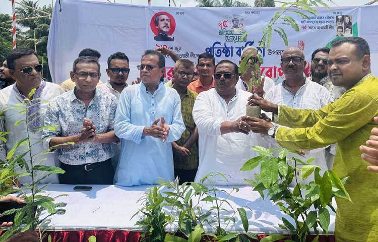 আওয়ামী লীগের ৭৫তম প্রতিষ্ঠাবার্ষিকী উপলক্ষে নওগাঁর নওযোয়ান মাঠে গাছের চারা বিতরণ করেন খাদ্যমন্ত্রী সাধন চন্দ্র মজুমদার। ছবি: পিআইডি