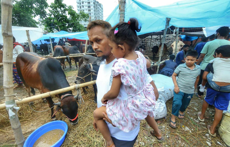 বাবার কোলে চড়ে হাটে এসেছে ছোট্ট শিশু।