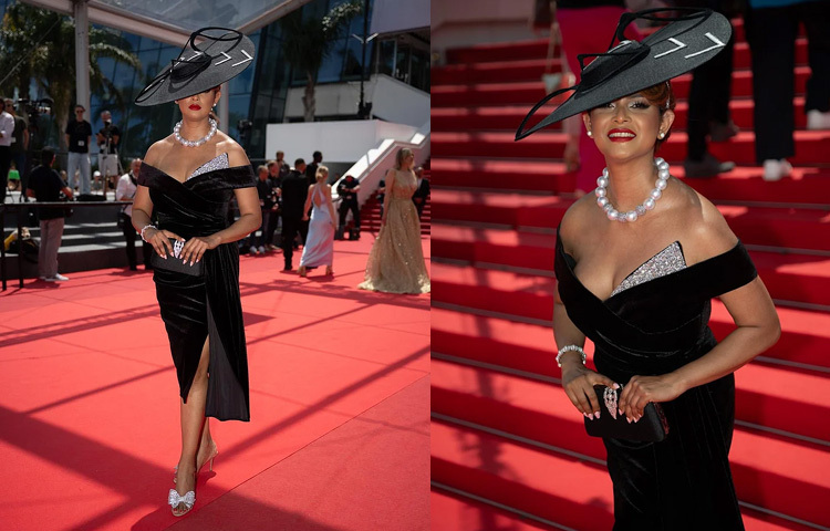 কানের পঞ্চম দিনে ভেলভেটের অফ-দ্য-শোল্ডার মিডি গাউনে রেড কার্পেটে দ্যুতি ছড়ান প্রিয়তি। গাউনটির সাইড স্লিট ডিজাইন নিখুঁতভাবে মিলেছে তার পায়ে পরা বো হিলের সঙ্গে। এই পুরো মনোক্রম কালো লুকের কেন্দ্রবিন্দু ছিল মাথায় থাকা বেস্পোক হ্যাটটি, যা আইরিশ ডিজাইনার ফিওনা রাফটার কাস্টমাইজ করে তৈরি করেছেন। লুকটিকে আরও নজরকাড়া করে তোলে প্রিয়তির লাল লিপস্টিক, মুক্তার তৈরি নেকপিস ও ব্রেসলেটের ঝলক। পরিপূর্ণতার ছোঁয়া আসে হাতে নেওয়া কালো ক্লাচের মাধ্যমে।