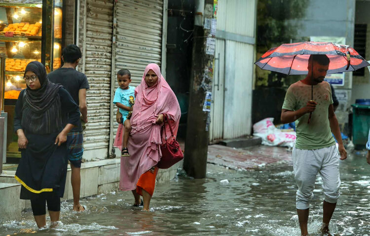 এক মায়ের হাত ধরে ভিজে যাওয়া ছেলেটির চোখেমুখে ছিল হাসি-হয়তো সে জানে না তার মা কী সংগ্রাম করে তাকে স্কুলে পৌঁছে দিচ্ছেন।
