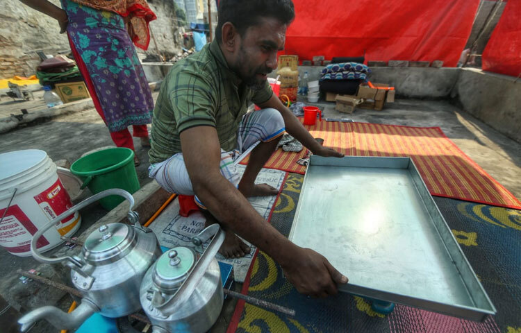 ছোট একটা চায়ের দোকান ছিল লোকটার। আগুনে এক মুহূর্তে সব উড়ে গেল; কাঁচের জারগুলো, ভাঙাচোরা টুল, মফিজের হাসিমাখা বিকেলের আড্ডা, সবই ছাই। কিন্তু আজ দুপুরে তাকে দেখা গেল নতুন চা দোকানের শেড তুলছেন। ধার নেওয়া টাকা দিয়ে, আবারও সাজাচ্ছেন নতুন করে। মিষ্টি চায়ের গন্ধ এখনও নেই, কিন্তু চায়ের উনুনের পাশে বসা তার ভরসার আদলে মনে হচ্ছিল এখানে খুব শিগগিরই আবার ভিড় হবে।