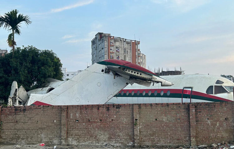 চারপাশে উঁচু প্রাচীর, সামনে টিনের বেড়া-ভেতরে ঢোকার সুযোগ নেই কারো। বাইরে দাঁড়িয়েই দেখা যায় সাদা রঙের প্লেন, জানালার গায়ে লাল-সবুজের আঁচড়।