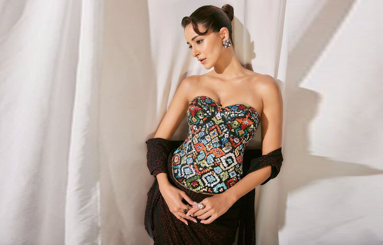 এই শাড়ির সঙ্গে অনন্যা পরেছিলেন পাটোলা মোটিফে সাজানো এক স্ট্র্যাপলেস করসেট ব্লাউজ, যার সুইটহার্ট নেকলাইন আর বিউগল বিডস এমবেলিশমেন্ট যেন পুরো লুকে এনে দিয়েছে প্রাণবন্ত উচ্ছ্বাস। রঙিন করসেট আর ঐতিহ্যবাহী শাড়ির এই যুগলবন্দি তার ফ্যাশন এক্সপেরিমেন্টেশনের নিখুঁত উদাহরণ।