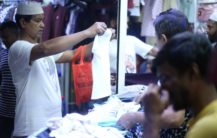 অনেকেই বাড়ি যাওয়ার আগে কিনে নিয়ে যাচ্ছেন প্রিয়জনের পছন্দের পোশাক। ছবি: মাহবুব আলম