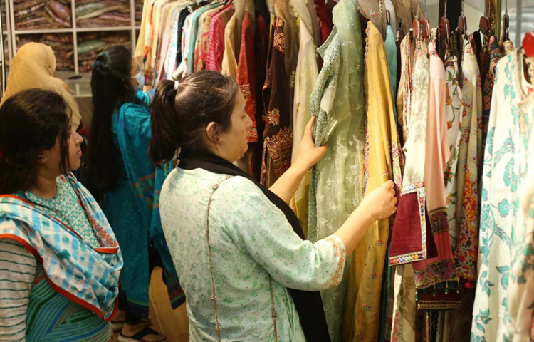 পছন্দের জামা খুঁজে নিচ্ছেন এক নারী। ছবি: মাহবুব আলম