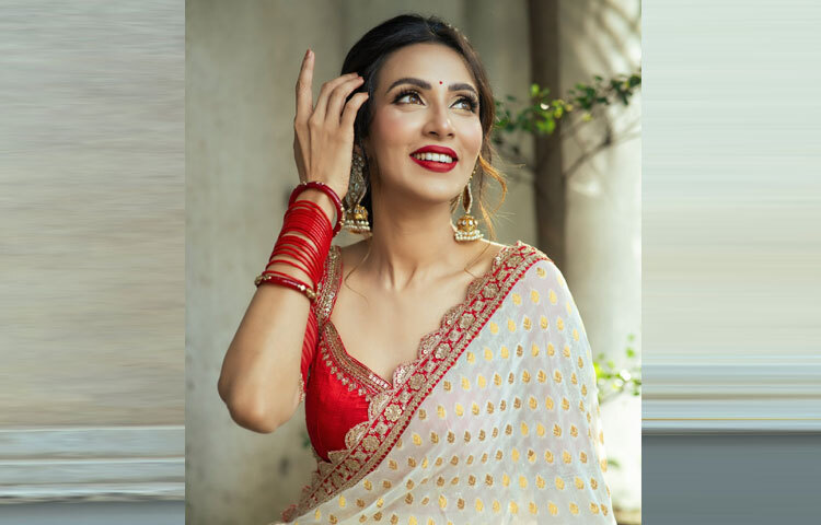 চোখে সোনালি আইশ্যাডো ও আইলাইনার, কপালে ছোট্ট লাল টিপ, ঠোঁটে লাল লিপস্টিক-সঙ্গে আত্মবিশ্বাসী হাসি।