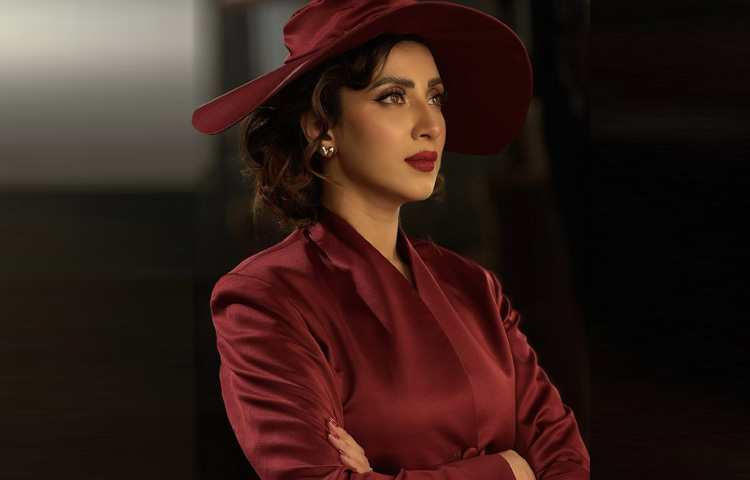 মেকআপেও রেখেছেন রেট্রোর মাধুর্য। গাঢ় লাল লিপস্টিক, নিখুঁত আইলাইনারে টানা চোখ, ঘন পাপড়ি আর ঝকঝকে ভ্রু। চুলে হালকা ওয়েভ দিয়ে হানি ব্রাউন রঙের ছোট কার্লি লুক, যেন পুরো অবয়বটাই এক রহস্যময় চরিত্র হয়ে উঠেছে।