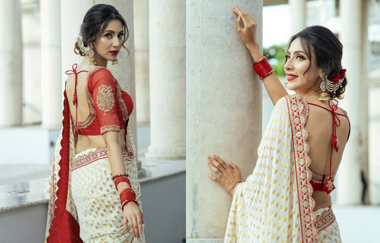 লাল রঙের পিঠখোলা ব্লাউজে সূক্ষ্ম সোনালি কারুকাজ তাকে দিয়েছে ভিন্ন আবেদন।