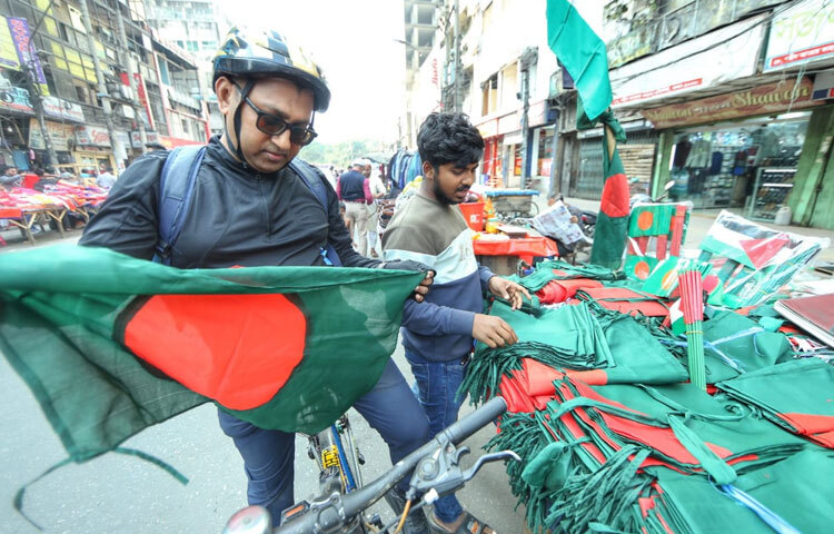 নানা বয়সের মানুষের ভিড়ে ফুটপাত যেন ক্ষণিকের উৎসবমুখর হয়ে ওঠে। কেউ নিজের জন্য, কেউবা বাচ্চাদের জন্য কিনে নিচ্ছেন দেশপ্রেমের প্রতীক এসব সামগ্রী।