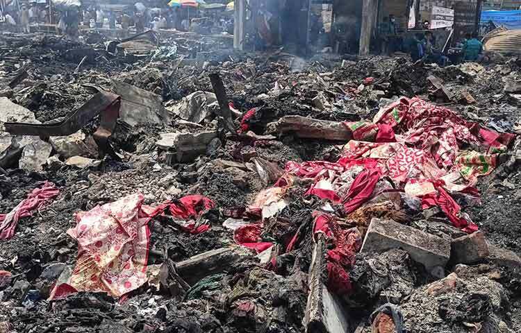 বঙ্গবাজারে আগুনে পুড়ে যাওয়া মালামাল সরানোর কাজ এখনো চলছে। পুড়ে ছাই হয়ে গেছে অধিকাংশ কাপড়। মাঝে-মধ্যে ধ্বংসস্ত’পের জঞ্জাল থেকে বের হচ্ছে নানা রঙের আধপোড়া শাড়ি। ব্যবসায়ীরা বলছেন, ক্ষয়ক্ষতির আর অবশিষ্ট কিছু নেই। ছবি: রাসেল মাহমুদ