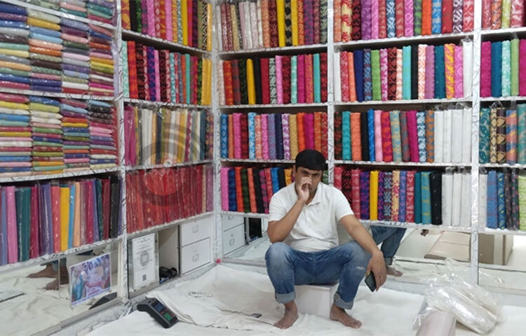 রাজধানীর মিরপুরের বেনারসি পল্লি। প্রায় সব দোকানই ক্রেতা শূন্য। অলস সময় পাড় করছেন দোকানীরা। তাদের কেউ কেউ মোবাইলে ভিডিও দেখছেন, আবার কেউ করছেন গল্প। বৃহস্পতিবার সকাল থেকে দুপুর ১২টা পর্যন্ত সেখানে অবস্থান করে দেখা গেলো, বলার মতো কোনো দোকানেই বেচাকেনা নেই। এই অবস্থায় হতাশা প্রকাশ করলেন ব্যবসায়ীরা। সাত রোজা চলে গেলেও বেচাকেনা শুরু হয়নি। ছবি: বিপ্লব দিক্ষিৎ