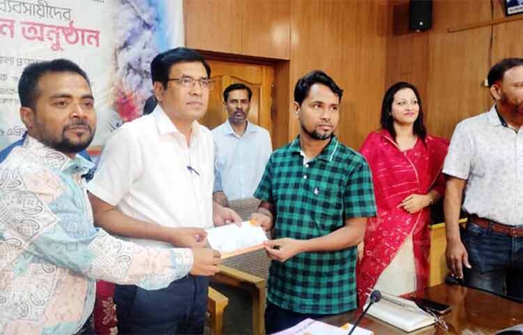 বঙ্গবাজারে অগ্নিকাণ্ডে ক্ষতিগ্রস্ত ৫০ ব্যবসায়ীকে নগদ অর্থ সহায়তা দিয়েছেন ঢাকা জেলা প্রশাসন। রোববার (১৬ এপ্রিল) ঢাকা জেলা প্রশাসক মোহাম্মদ মমিনুর রহমান ব্যবসায়ীদের ২০ হাজার টাকা অনুদান দেন। ছবি: জাগো নিউজ