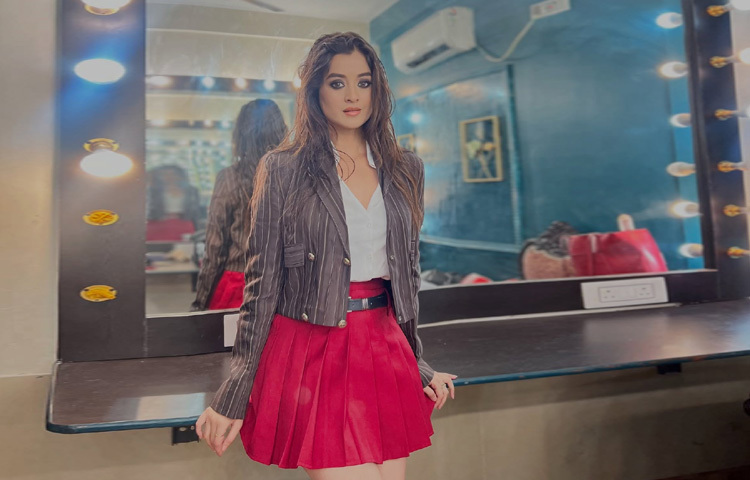 এলোমেলো চুল সাদা টপ ও লাল শর্ট স্কার্টে দারুণ লাগছে তাকে।