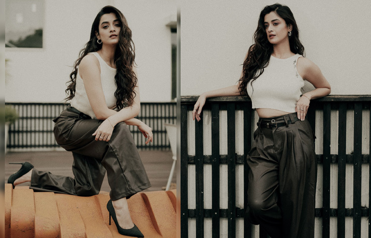 সাদা স্লিভলেস ক্রপ টপের সঙ্গে গ্লসি ফেব্রিকের কালো কার্গো প্যান্টে বেশ স্টাইলিশ লাগছে। আর এই সৌন্দর্যকে দ্বিগুণ করে তুলেছে তার স্টাইলিশ স্টিলেটো হিলস।