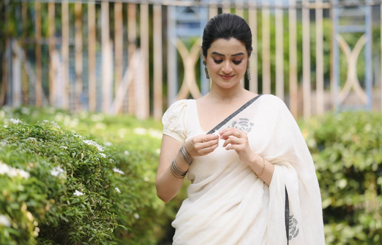 সাদা শাড়ি, হালকা মেকআপ আর খোঁপায় বেশ স্নিগ্ধ লাগছে তাকে।