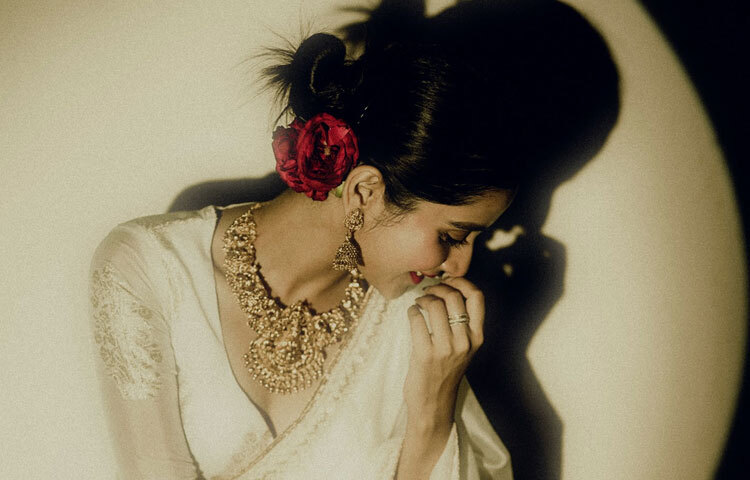 সাদা শাড়িতে দেবচন্দ্রিমা সিংহ রায়ের খোঁপা যেন অনন্ত সৌন্দর্যের প্রতীক। নিখুঁতভাবে বাঁধা খোঁপার পাশে লাল গোলাপ গুঁজে দিলে যে রোমান্টিক আবেদন সৃষ্টি হয়, তা যে কোনো অনুষ্ঠানের জন্য যথেষ্ট।