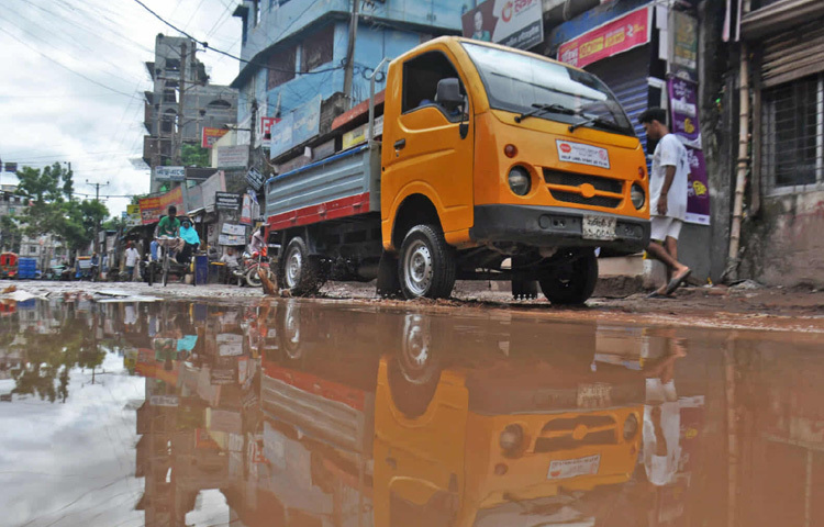 বর্ষা এলেই পুরো রাস্তা রূপ নেয় জলাশয়ে। আর সেই পানির নিচে লুকিয়ে থাকা গর্ত যেন হয়ে ওঠে মৃত্যুফাঁদ।