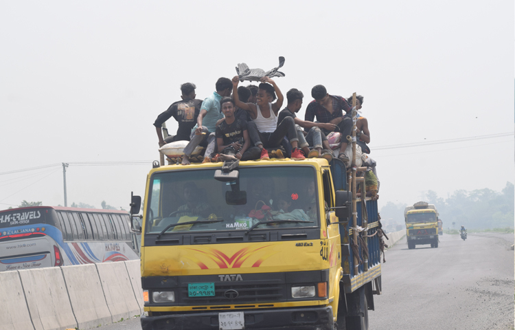 তবে বাসে অতিরিক্ত ভাড়া ও সিট না পেয়ে জীবনের ঝুঁকি নিয়ে ট্রাকে করে গন্তব্যে ফিরছেন পোশাকশ্রমিকরা। ছবি: এম এ মালেক