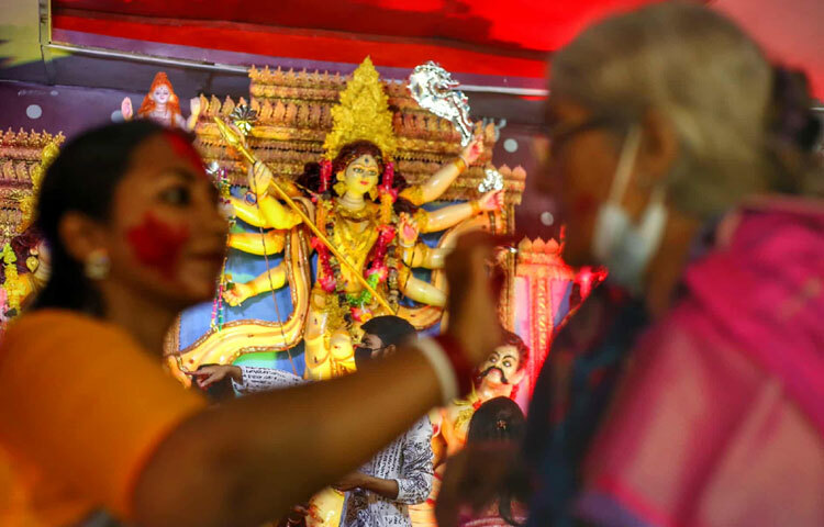 লাল-শাড়ি-সাজে, শঙ্খ আর উলুধ্বনিতে মুখরিত হয়ে উঠল মন্দির প্রাঙ্গণ।