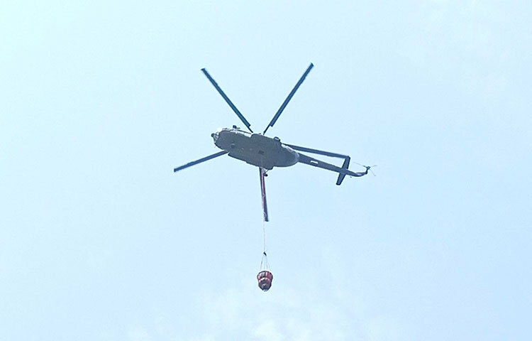 হেলিকপ্টার দিয়ে পানি ছিটিয়ে আগুন নেভানোর চেষ্টা করা হচ্ছে। ছবি: জাগো নিউজ