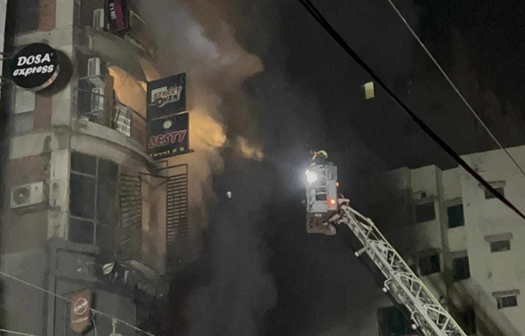 আগুন লাগার সঙ্গে সঙ্গেই ধোঁয়ায় আছন্ন হয়েছিল চারপাশ। এর মধ্যেই আগুন নেভানোর কাজ চালিয়ে গেছে ফায়ার সার্ভিসের কর্মীরা। ছবি: তৌহিদুজ্জামান তন্ময়