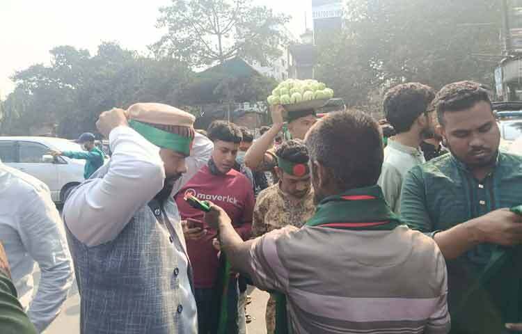 খামার বাড়ি থেকে জানাজাস্থলে প্রবেশ মুখে জাতীয় পতাকা মাথায় বেঁধে নিচ্ছেন জানাজা পড়তে আসা মুসল্লিরা।