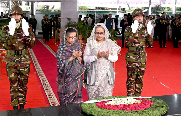 জাতির পিতা বঙ্গবন্ধু শেখ মুজিবুর রহমানের ১০৪তম জন্মবার্ষিকী ও জাতীয় শিশু দিবস উদযাপন উপলক্ষ্যে প্রধানমন্ত্রী শেখ হাসিনা তার ছোট বোন শেখ রেহানাকে সঙ্গে নিয়ে ধানমন্ডি ৩২ নম্বরে বঙ্গবন্ধুর প্রতিকৃতিতে পুষ্পস্তবক অর্পণ শেষে মোনাজাতে অংশ নেন। ছবি: পিআইডি