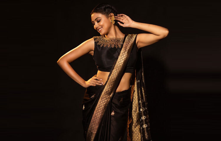 ইধিকার সাম্প্রতিক ফটোশুটে তাকে দেখা গেছে কালো সিল্ক শাড়িতে। মসৃণ সিল্কের ওপর মেটালিক গোল্ড বর্ডার যেন আলো ছুঁয়ে তৈরি করেছে এক স্বর্ণালী আবেশ। পাড়ে জ্যামিতিক নকশা আর সূক্ষ্ম সোনালি কারুকাজ পুরো সাজে এনে দিয়েছে এক নিখাদ রাজকীয় অনুভূতি।