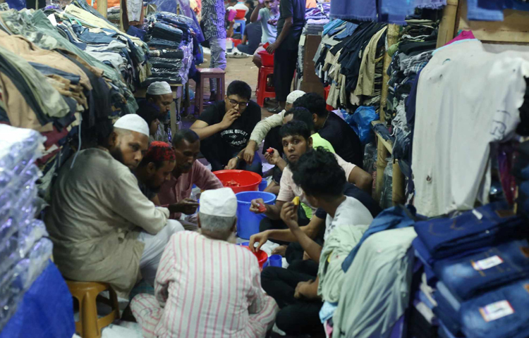 বেচাকেনার ফাঁকেই ইফতার করে নিচ্ছেন দোকানিরা। ছবি: মাহবুব আলম