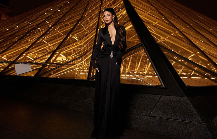 এই বিশেষ ইভেন্টে জ্যাকুলিন বেছে নেন এক দৃষ্টিনন্দন কালো গাউন। গভীর প্লাঞ্জিং নেকলাইন আর ফিটেড সিলুয়েট তাকে দিয়েছে এক বোল্ড অথচ মার্জিত আবেদন।