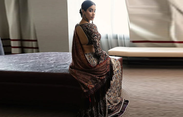 শাড়িটি হাতে সূচিকর্ম করা, যেখানে উষ্ণ শরৎ রঙের সূতায় জটিল ফুলেল মোটিফ নকশিকাঁথার মতো ফুটে উঠেছে। শুধু শাড়িই নয়, ব্যাকলেস ব্লাউজটিও ছিল সূক্ষ্ম এমব্রয়ডারিতে আচ্ছাদিত, যা লুকটিতে একযোগে সৌন্দর্য এবং শৈল্পিক ধারাবাহিকতা এনেছে।