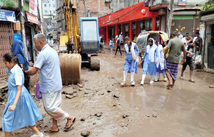 পথচারীদের অবস্থাও তথৈবচ। অফিসমুখী মানুষ হেঁটে চলতে গিয়ে হয় কোমরসমান পানিতে আটকে পড়ছেন, নয়তো গর্তে পা পড়ে আহত হচ্ছেন। হঠাৎ করে পানি জমে থাকায় বাইক ও রিকশাচালকদেরও পড়তে হচ্ছে চরম ভোগান্তিতে। গাড়ির চাকা আটকে যাচ্ছে কাদায়, রিকশা উল্টে যাচ্ছে জলমগ্ন গর্তে।