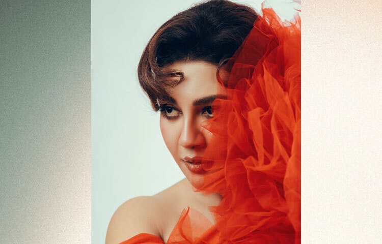 চুলে রেট্রো স্টাইল, লাল ঠোঁট, ঘন আইলাইনার-মাসকারা আর কানের ঝুলন্ত দুল যেন পুরো লুকটিকে পরিপূর্ণ করেছে।