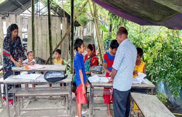 গোটা এলাকাজুড়ে পানিতে টইটুম্বুর। তাই বলে তো আর লেখাপড়া থেমে থাকবে না। তাই বাড়ির উঠানে তাঁবু টাঙিয়ে চলছে লেখাপড়া। এ দৃশ্য যশোরের মণিরামপুরের ভুলবাড়িয়া সরকারি প্রাথমিক বিদ্যালয়ের শিক্ষার্থীদের। ছবি: জাগো নিউজ