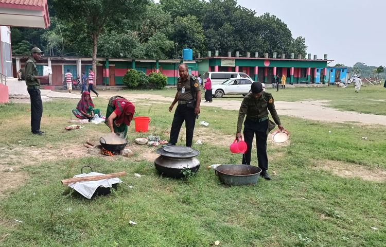 উপজেলা পরিষদ নির্বাচনে গাজীপুরের কালীগঞ্জে ভোটার উপস্থিতি কম থাকায় দুপুরের রান্না-বান্নার আয়োজনে ব্যস্ত কেন্দ্রের দায়িত্বে থাকা নারী ও পুরুষ আনসার সদস্যরা। ছবি: আব্দুর রহমান আরমান