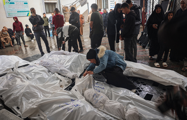 লাশের ভিড়ে স্বজনদের খুঁজে বেড়াচ্ছেন এক নারী। ছবি: এএফপি