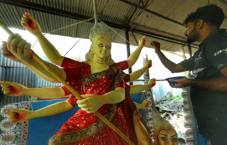 কারিগরদের কেউ মূর্তির গায়ে তুলির টানে আনছেন প্রাণের স্পর্শ, কেউ রঙ করছেন দেবীর হাত কিংবা পা।