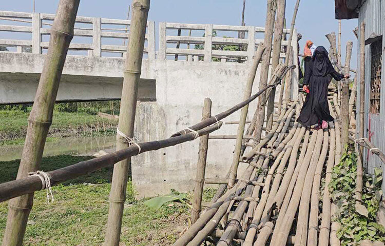 মাদারীপুরের কালকিনি উপজেলার লক্ষ্মীপুর ইউনিয়নের একটি সেতুতে উঠতে হয় বাঁশের সাঁকো দিয়ে। এতে এলাকার মানুষকে যাতায়াতের জন্য চরম ভোগান্তিতে পড়তে হচ্ছে। ছবি: আয়শা সিদ্দিকা আকাশী