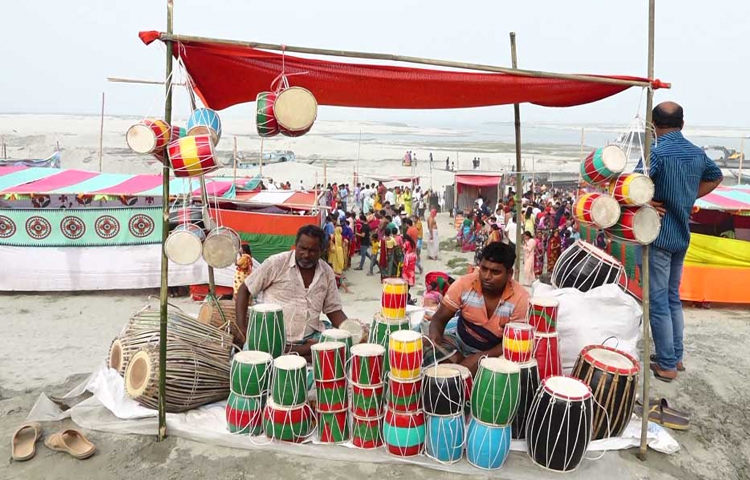 বারুণীর স্নান ঘিরে নদীর পাড়ে বসেছে গ্রামীণ মেলা। ছবি: বি.এম খোরশেদ