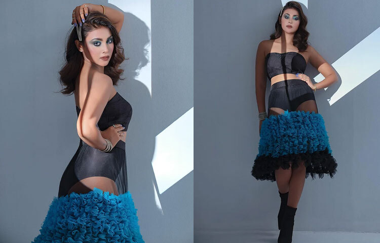 স্ট্র্যাপলেস কালো ক্রপ টপের সঙ্গে শিয়ার ফেব্রিকের নীল-কালো রাফেল স্কার্ট, মেঘলার এই পোশাকে একদিকে আভিজাত্য, অন্যদিকে খেলা করছে ফ্যাশন–ফরোয়ার্ড ভাব। নীল আই মেকআপ তার চোখের অভিব্যক্তিকে করেছে আরও গভীর ও আকর্ষণীয়।