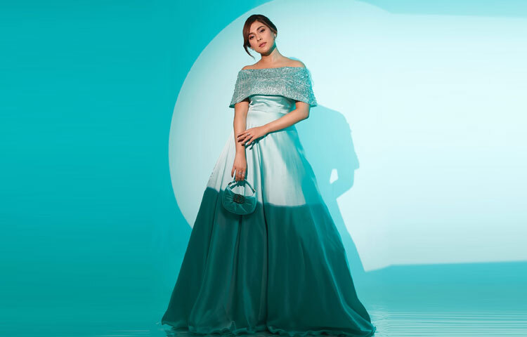 অফ-শোল্ডার ডিজাইনের পোশাকটিতে রুপালি সিকুইনের ঝলক তার রূপকে এনে দিয়েছে এক নতুন মাত্রা।