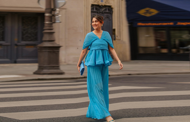 ব্যাকলেস প্লিটেড টপের সঙ্গে ম্যাচ করে পরেছেন ওয়াইড লেগ প্যান্ট। তার সঙ্গে রয়েছে সোনালি হিল, যা পুরো লুকটিকে এনে দিয়েছে এক ঝলমলে ভারসাম্য।