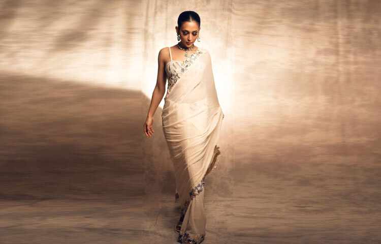 মনোক্রম শাড়িটির সিলভার-গোল্ড এমব্রয়ডারির ফ্লোরাল নকশা নজর কাড়লেও আসল আকর্ষণ ছিল তার ব্লাউজে।