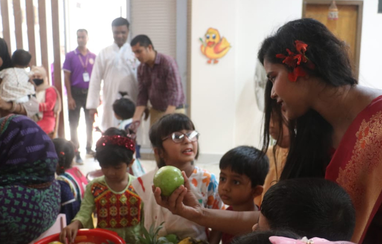 শিক্ষার্থীদের বিভিন্ন দেশীয় ফলের সঙ্গে পরিচয় করিয়ে দেন শিক্ষকরা। ছবি: রাকিব হাসান